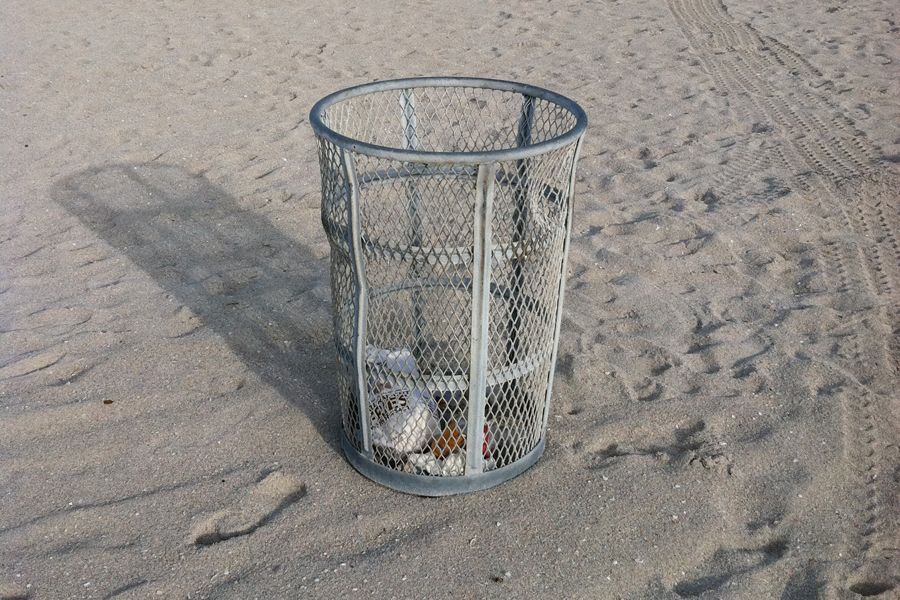 Image of a metal trash can on a beach.